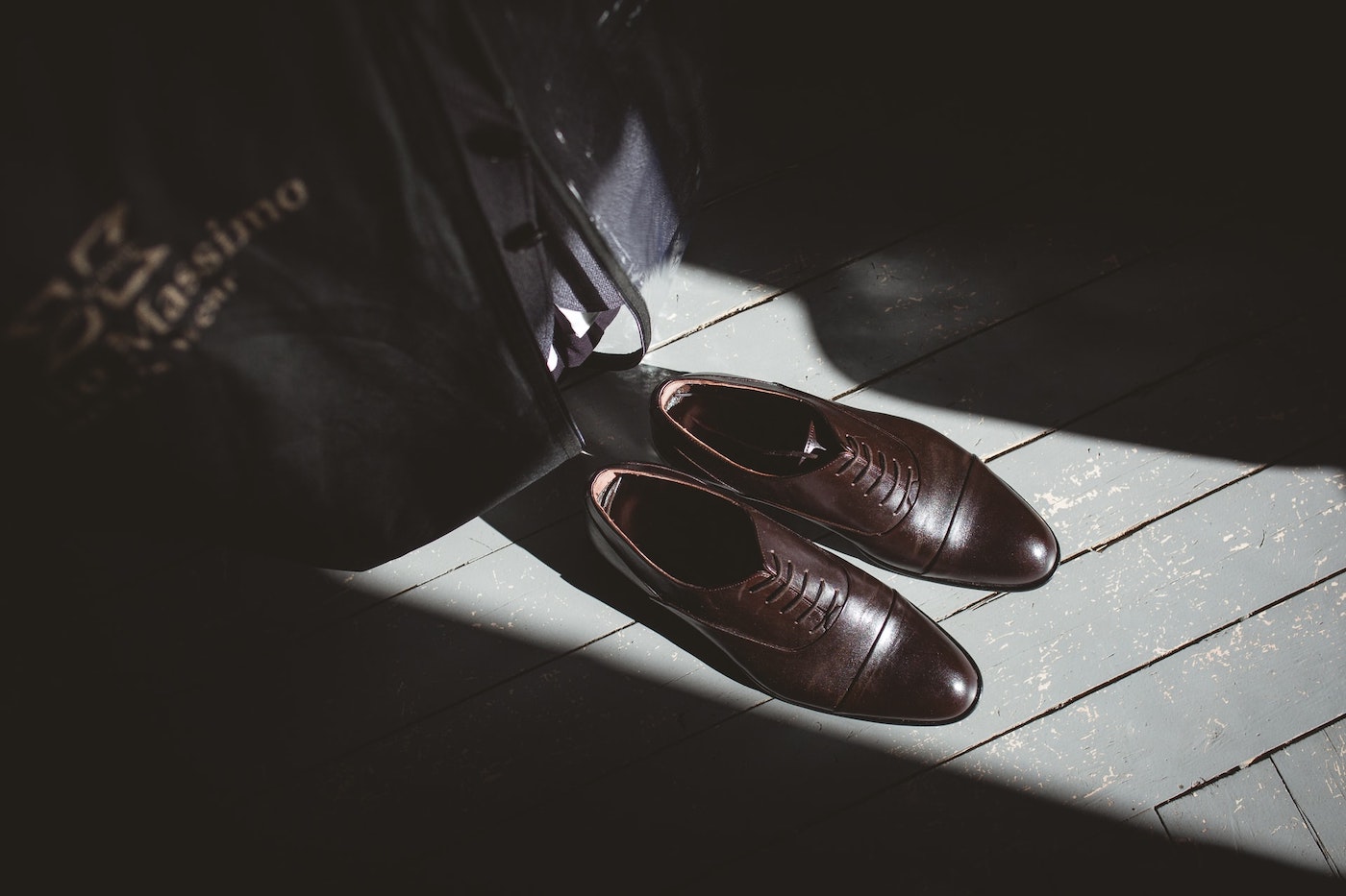 Brown shoes and a black suit in the sunlight