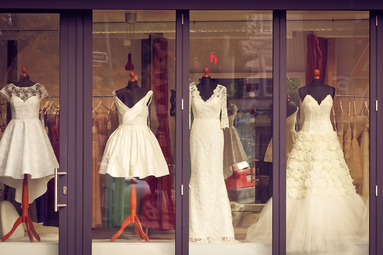 Four wedding dresses in the front window of a store